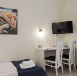 Una habitación con una cama, un escritorio y un televisor. en B&b flats, en Wroclaw