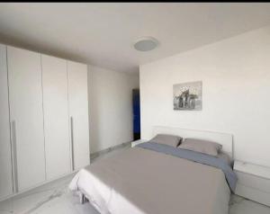a white bedroom with a bed and white cabinets at B&b flats in Wrocław