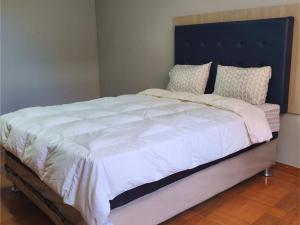 een groot bed met witte lakens en kussens erop bij Casa Historia - Hospedaje in Cajamarca