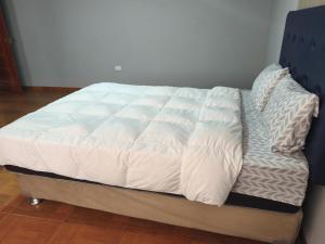 een bed met witte lakens en kussens erop bij Casa Historia - Hospedaje in Cajamarca