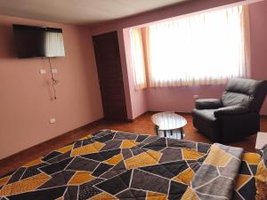 een slaapkamer met een bed, een bank en een stoel bij Casa Historia - Hospedaje in Cajamarca