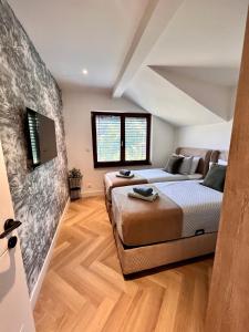 萨拉热窝The Penthouse Sarajevo的一间卧室，配有两张床和一台平板电视