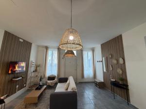 un salon avec un canapé et un lustre dans l'établissement Le clair de lune, à Saint-Amand-les-Eaux