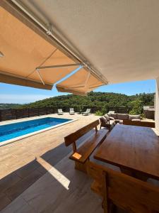 eine Terrasse mit Tisch und Swimmingpool in der Unterkunft Villa Prezzi in Novo Selo