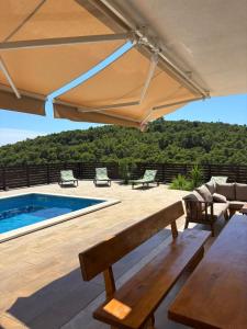 eine Terrasse mit Sonnenschirm und Swimmingpool in der Unterkunft Villa Prezzi in Novo Selo