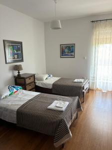 ein Hotelzimmer mit zwei Betten und einem Fenster in der Unterkunft Villa Prezzi in Novo Selo