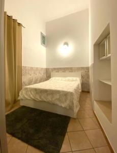a small bedroom with a bed with a white comforter at Morgera N8 in Forio d'Ischia