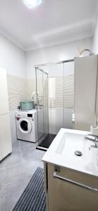 eine Küche mit Waschmaschine und Mikrowelle in der Unterkunft Kos Apartment - Elodie Paradise in Mogán