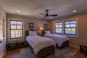 ein Schlafzimmer mit zwei Betten und zwei Fenstern in der Unterkunft Lakeshore Retreat at Sweetgrass in Blowing Rock