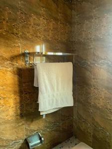 - une serviette accrochée au mur dans la salle de bains dans l'établissement Essérè Mabia hôtel E-M, à Brazzaville