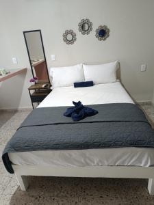 Un dormitorio con una cama con una bata azul. en Suite 105 Cordoba centro y estacionamiento, en Córdoba