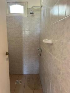 a bathroom with a shower with a tiled wall at Aiken Embalse in Embalse +20 photos