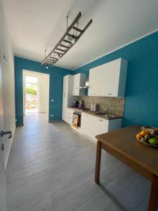 a kitchen with blue walls and a table with a bowl of fruit at B&B Dai Nonni in Mongiove