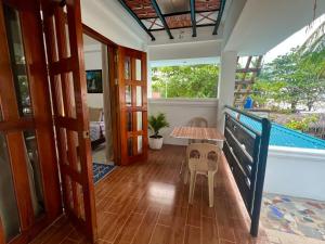 einen Balkon eines Hauses mit einem Tisch und einem Tisch in der Unterkunft Treasure Beach Resort in Carles