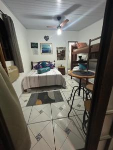 a bedroom with a bed and a table at Suite de Lane e Mu in Abraão