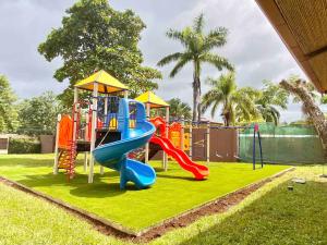 einen Spielplatz mit Rutsche auf dem Rasen in der Unterkunft Peninsula Langosta in Tamarindo