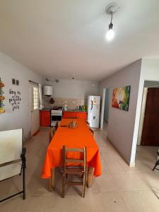 eine Küche mit einem Tisch mit einer orangefarbenen Tischdecke darauf in der Unterkunft El Descanso in Concepción