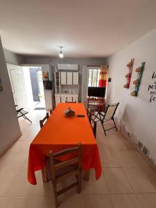 ein Esszimmer mit einem orangefarbenen Tisch und Stühlen in der Unterkunft El Descanso in Concepción