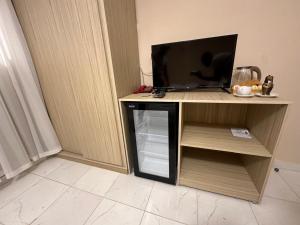 ein kleiner Schrank mit einem Fernseher und einem kleinen Kühlschrank in der Unterkunft pumaa pyramids giza INN in Kairo