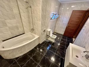 ein Badezimmer mit Badewanne, Toilette und Waschbecken in der Unterkunft pumaa pyramids giza INN in Kairo