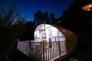 Una casa abovedada con una luz encendida por la noche. en The Lush Pods, en Jāmb