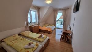 a bedroom with two beds and a desk and a balcony at Willa u Skrajnioka in Czerwienne