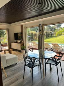 un soggiorno con tavolo e sedie in vetro di Calma a Punta Colorada