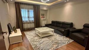 Sheikh ZayedBeverly Gardens Retreat- منتجع حدائق بيفرلي的带沙发和咖啡桌的客厅