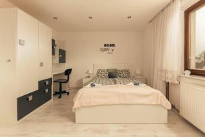 a white bedroom with a bed and a desk at Apartment Mountain Sunrise in Škofja Loka