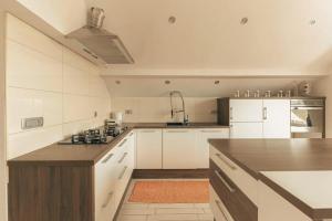 a kitchen with white cabinets and a wooden counter top at Apartment Mountain Sunrise in Škofja Loka