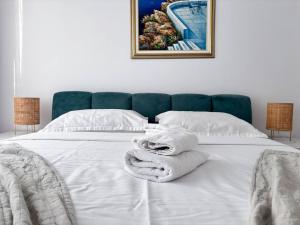a bedroom with a bed with white towels on it at Sunshine Luxury Apartment Private Parking in Cluj-Napoca