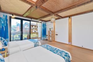 a bedroom with two beds and a large window at Xijiang Longtang Liyuan Mountain Resort B&B in Leishan