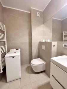 a bathroom with a white toilet and a sink at Sunshine Luxury Apartment Private Parking in Cluj-Napoca +13 photos