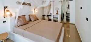 a white bedroom with a bed with two pillows at Casa Cesaria Guest House in Sal Rei
