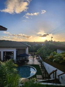 une vue d'une maison avec piscine et un coucher de soleil dans l'établissement Praia do Forte - Mansão Sunset, à Mata de São João