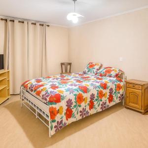 ein Schlafzimmer mit einem Bett mit geblümter Bettdecke in der Unterkunft gîte 8 personnes Les Marqueries in La Flèche + 8 Fotos