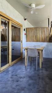 a table and a chair in a room with a ceiling at Lagalag Studios in El Nido