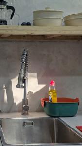 a kitchen sink with a bottle of cleaning agent sitting next to a kitchen sink at Lagalag Studios in El Nido