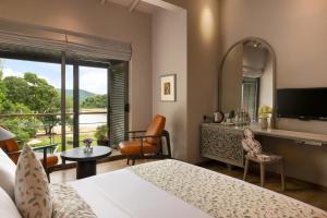 a hotel room with a bed and a large window at Mapakada Village - Wild Trails & Lake Retreat - Mahiyanganaya in Mahiyangana