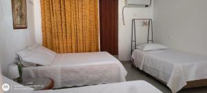 una piccola stanza con due letti e un tavolo di Hostal Casa de las Americas a Cartagena de Indias