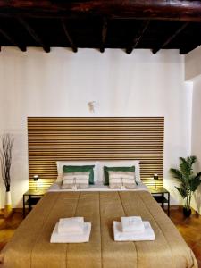 Un dormitorio con una cama grande con dos toallas blancas. en La Magia del Borgo, en Genzano di Roma