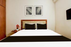 Un dormitorio con una cama blanca con dos almohadas. en Hotel O Akshaya Enikepadu, en Vijayawāda