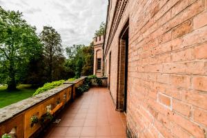 a brick building with a walkway next to a wall at Zamek Rzucewo in Rzucewo