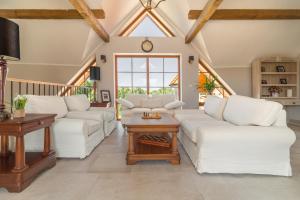 a living room with white couches and a table at Pensjonat Rybical in Ryn