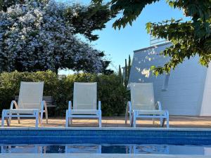 two blue and white chairs sitting next to a swimming pool at Starbal Love in Es Castell