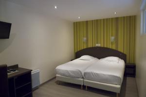a bedroom with a bed with white sheets and pillows at Auberge de la Baie in Ardevon