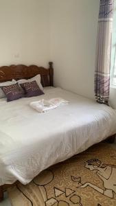 a bed in a bedroom with a white sheets and pillows at Namfrey Sunny in Kiserian