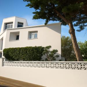 une maison blanche avec une clôture blanche et un arbre dans l'établissement Starbal Love, à Es Castell