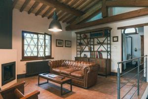 Una sala de estar con un sofá de cuero y una mesa. en Historic Villa With Pool In Umbrian Hills, en Umbertide