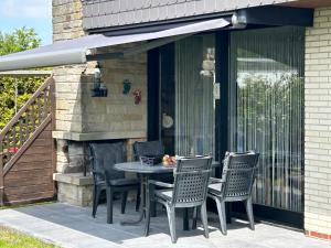a patio with a table and chairs on a porch at Friesenkoje Tossens in Butjadingen